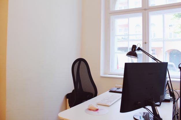 Schreibtisch mit Büroausstattung vor einem Fenster im Berliner Büro