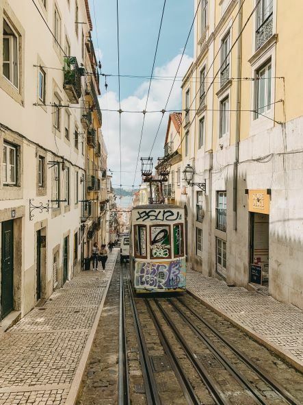 Alte, heruntergekommene Straße auf der eine mit Graffiti beschmierte Straßenbahn fährt