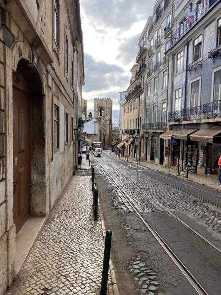 Straße in Lissabon umgeben von Gebäuden an einem bewölkten Tag
