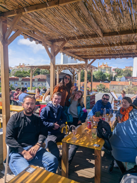 Online Birds Mitarbeitende die in Lissabon an einem Tisch sitzen und etwas trinken