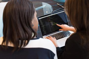 Zwei Frauen die am Laptop Codes überprüfen