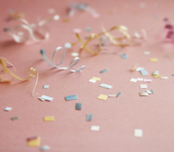 Buntes Konfetti auf einem rosa Hintergrund