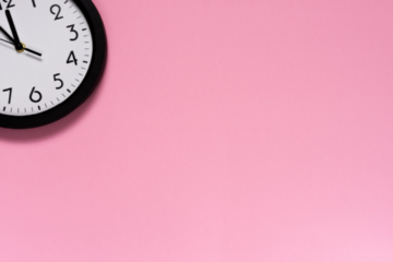 Runde Uhr in der Ecke vor einem pinken Hintergrund