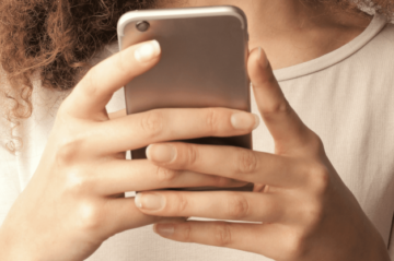 Frau, die ein Handy in ihren Händen hält