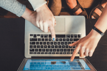 Finger die auf einen Laptop zeigen