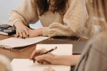 Zwei Frauen die zusammen ihre Notizen durchgehen
