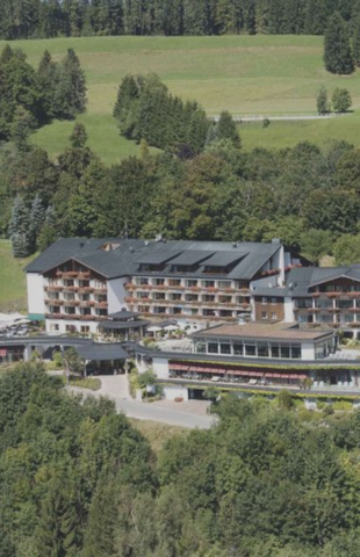 Fernaufnahme des Hotels, unseres Kunden Thurnhers Alpenhof, welches von Bäumen und Wiese umgeben ist