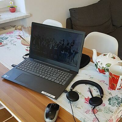 Homeoffice Ausstattung auf den Essenstisch mit einer älteren Teekanne daneben